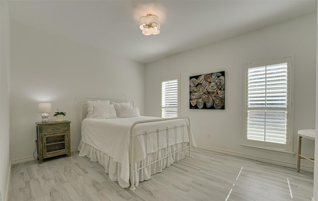 bedroom with light wood-type flooring and multiple windows