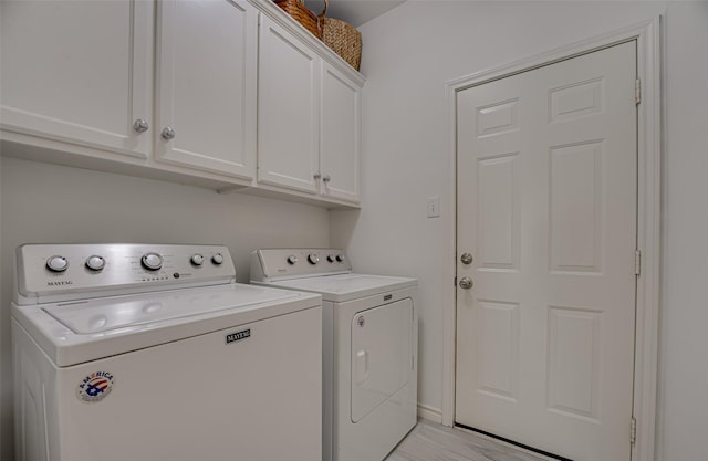 laundry area featuring washing machine and dryer and cabinets