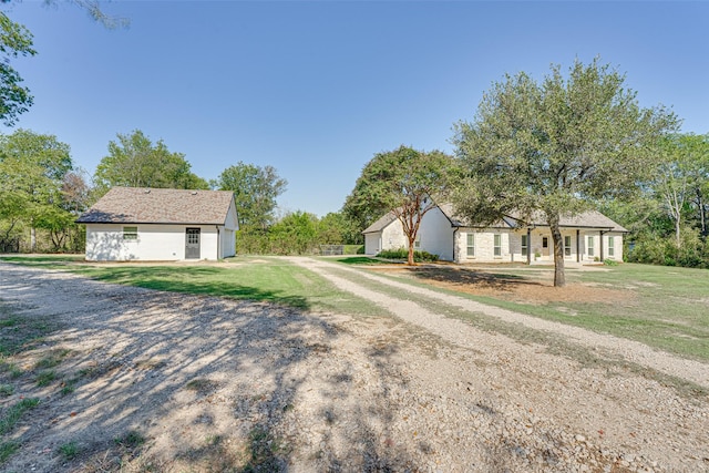 view of front of house with an outdoor structure and a front yard