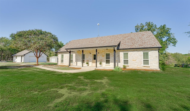 view of front of home with an outdoor structure, a front lawn, a porch, and a garage