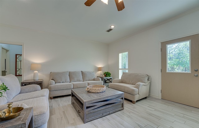 living room with ceiling fan, a healthy amount of sunlight, crown molding, and light hardwood / wood-style flooring