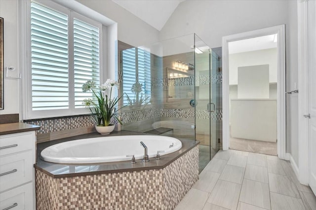 bathroom with vanity, lofted ceiling, and plus walk in shower