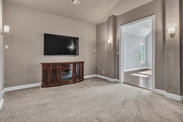 unfurnished living room with carpet flooring and lofted ceiling