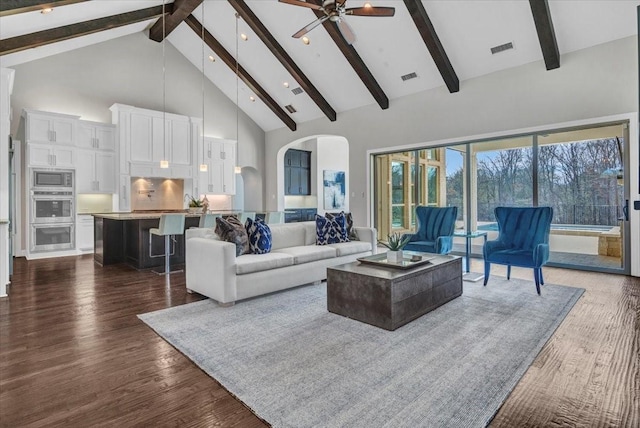 living room featuring beam ceiling, dark hardwood / wood-style flooring, high vaulted ceiling, and ceiling fan