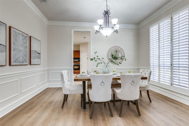 dining area featuring ornamental molding, light hardwood / wood-style flooring, and a wealth of natural light