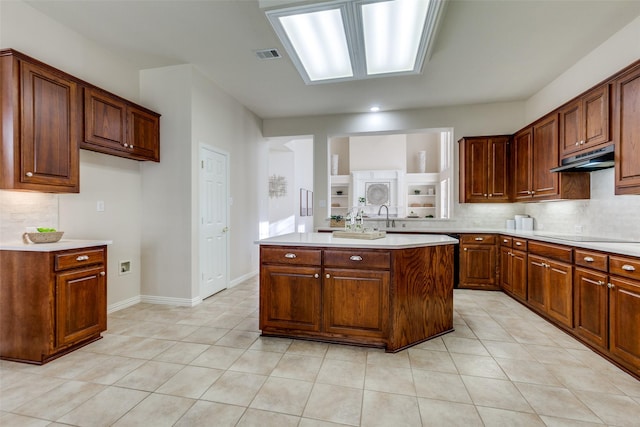 kitchen featuring a kitchen island, light tile patterned floors, backsplash, and black electric cooktop