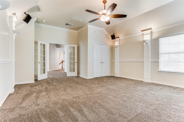 unfurnished bedroom featuring lofted ceiling, french doors, crown molding, ceiling fan, and carpet floors