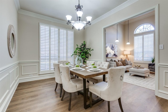 dining room with hardwood / wood-style floors, a chandelier, and ornamental molding