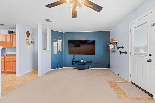 living area featuring visible vents, ceiling fan, light carpet, and baseboards