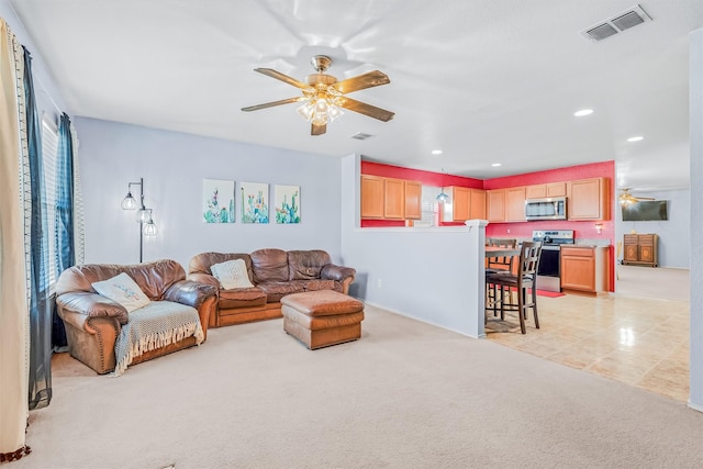 living room featuring light carpet, ceiling fan, visible vents, and recessed lighting