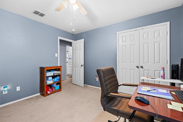 home office with a ceiling fan, light colored carpet, visible vents, and baseboards