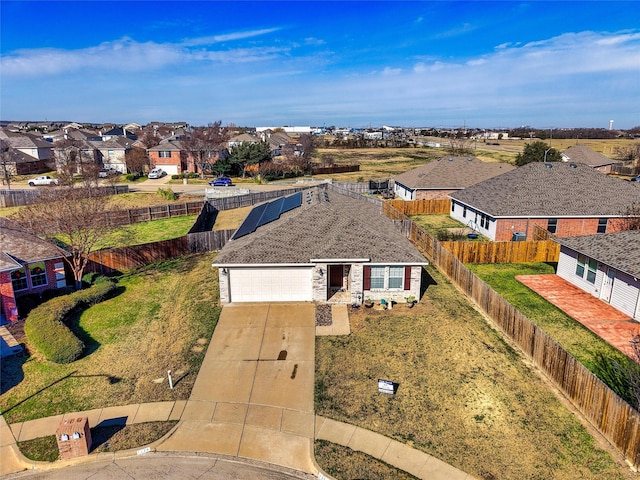 view of front of property with solar panels, a garage, and a front yard