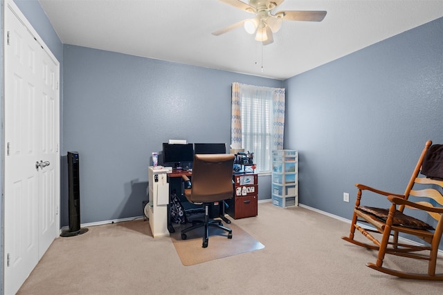 carpeted home office featuring baseboards and a ceiling fan