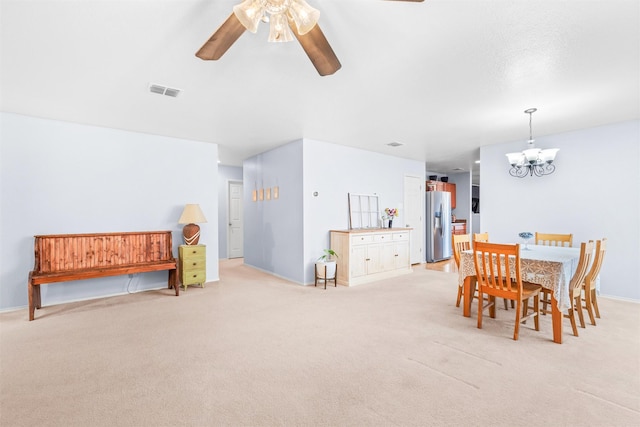 dining area with ceiling fan with notable chandelier, visible vents, and light colored carpet