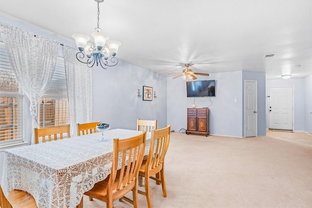 dining space featuring ceiling fan with notable chandelier, visible vents, and light colored carpet