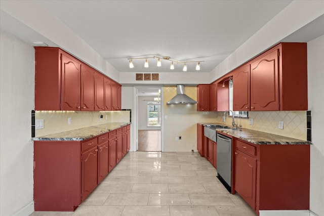 kitchen with decorative light fixtures, dark stone countertops, decorative backsplash, stainless steel dishwasher, and wall chimney range hood