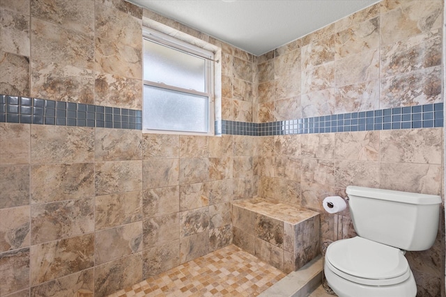 bathroom featuring tiled shower, tile walls, and toilet