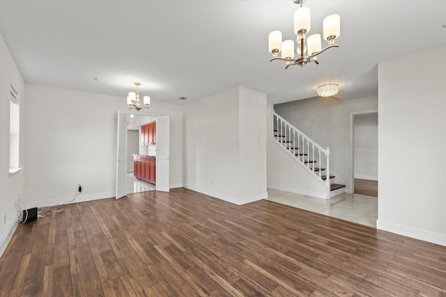 empty room with an inviting chandelier and hardwood / wood-style flooring