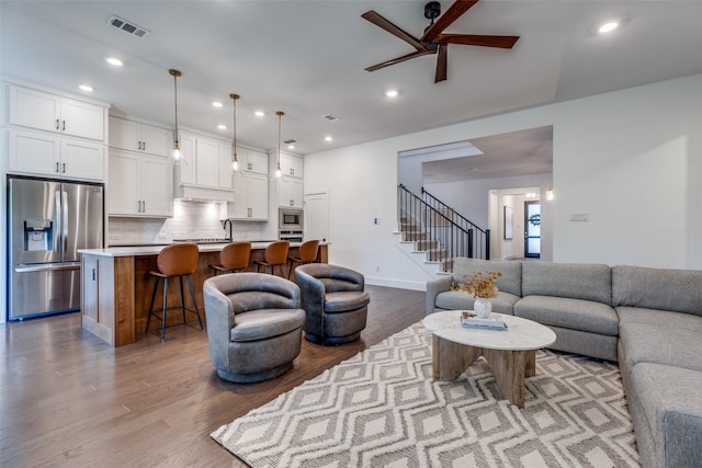 living room with light hardwood / wood-style flooring and ceiling fan