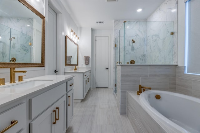 bathroom with vanity and separate shower and tub