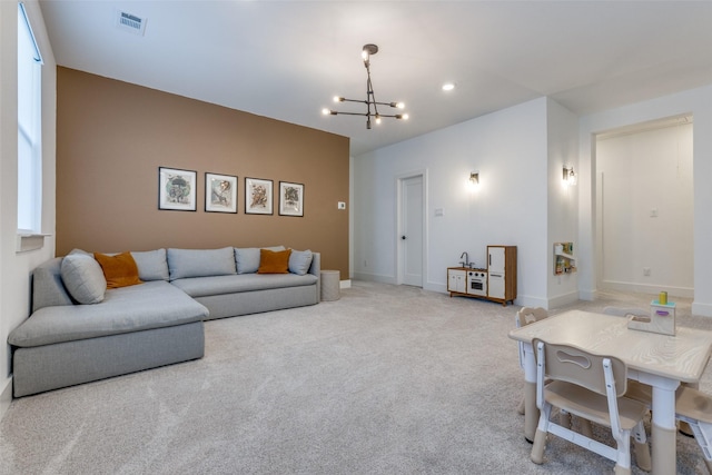 carpeted living room with an inviting chandelier