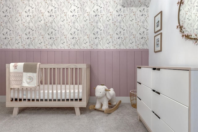 bedroom featuring a nursery area and light carpet