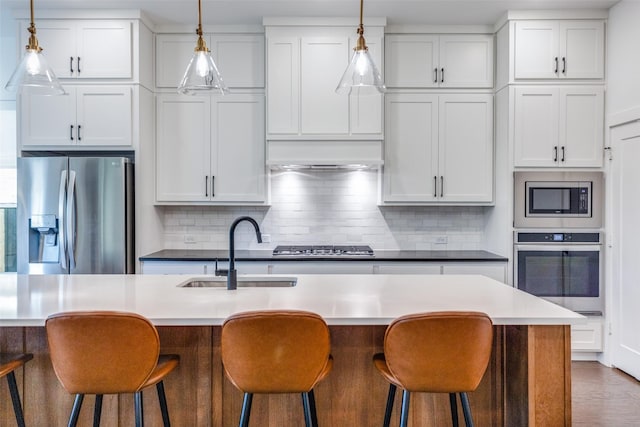 kitchen with white cabinetry, sink, an island with sink, and appliances with stainless steel finishes