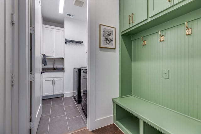 mudroom with separate washer and dryer, sink, and dark tile patterned floors