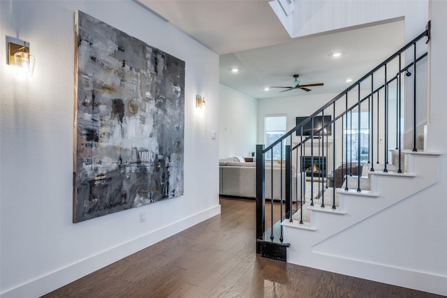 stairway featuring hardwood / wood-style flooring, a skylight, and ceiling fan