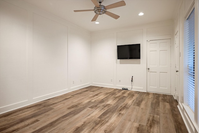 unfurnished living room featuring ceiling fan and hardwood / wood-style flooring