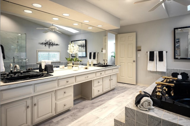 bathroom featuring vanity, a skylight, an enclosed shower, and ceiling fan