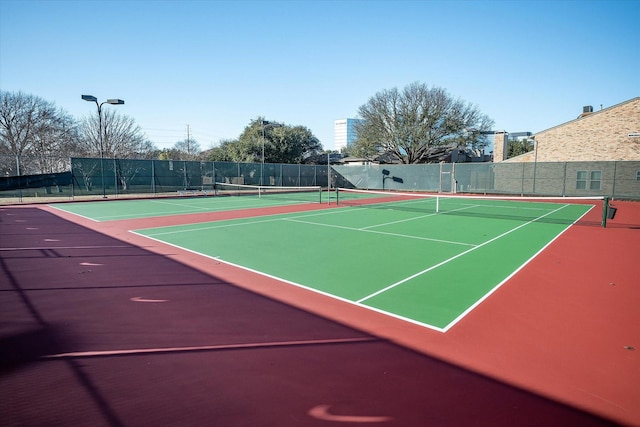 view of tennis court with basketball hoop