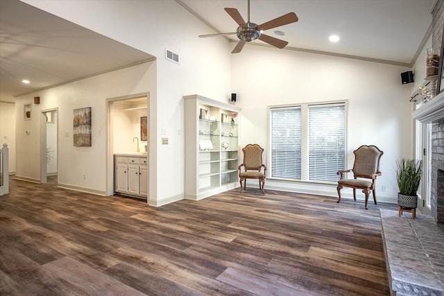 sitting room with ceiling fan, sink, a brick fireplace, dark hardwood / wood-style flooring, and crown molding