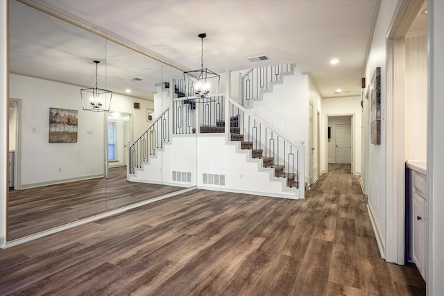 interior space featuring dark wood-type flooring, stairway, visible vents, and a notable chandelier