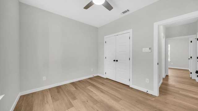 unfurnished bedroom with a closet, light hardwood / wood-style flooring, and ceiling fan