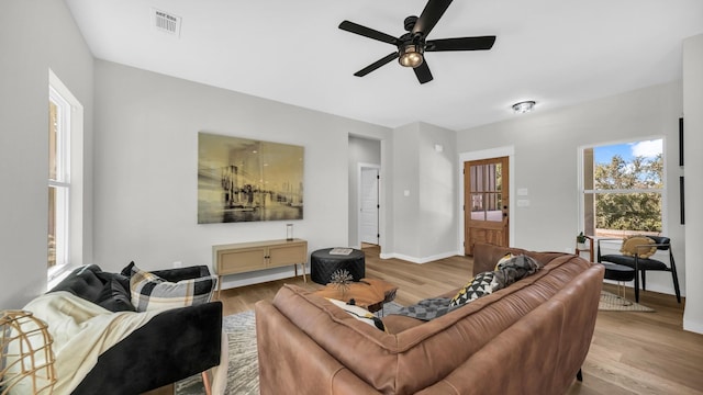 living room featuring light hardwood / wood-style flooring and ceiling fan