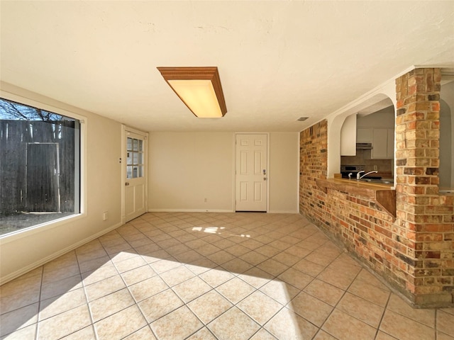 unfurnished living room featuring sink and light tile patterned floors