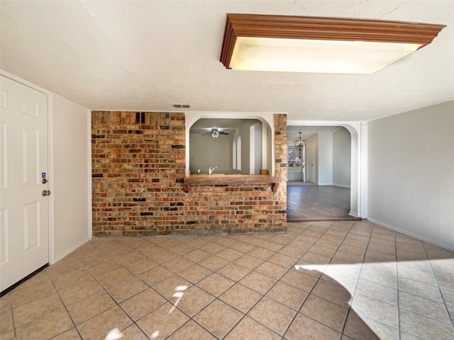 interior space featuring ceiling fan, light tile patterned flooring, and a textured ceiling