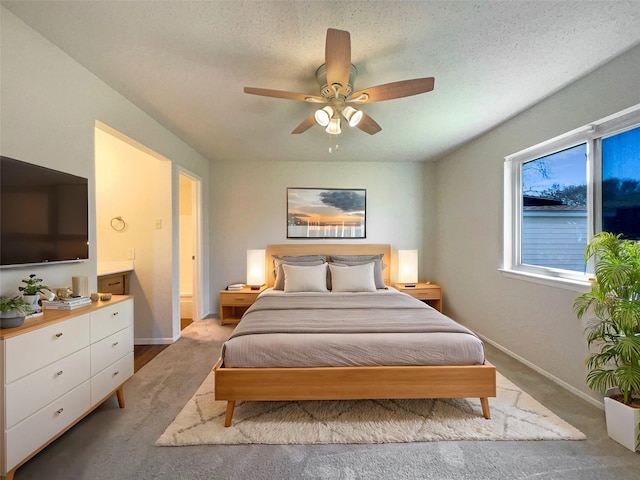 carpeted bedroom with ceiling fan and a textured ceiling