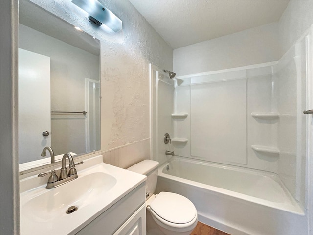 full bathroom with tub / shower combination, a textured ceiling, vanity, hardwood / wood-style flooring, and toilet