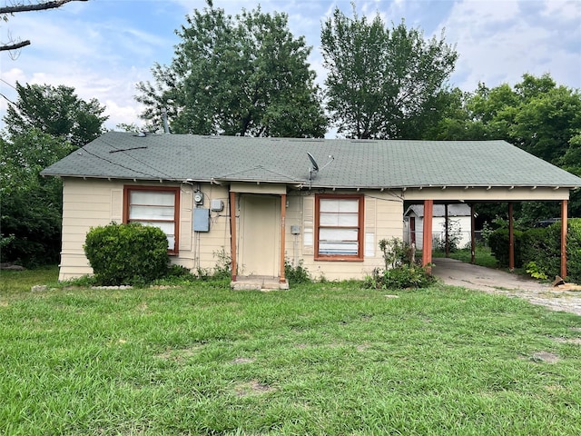 ranch-style house featuring a front lawn and a carport