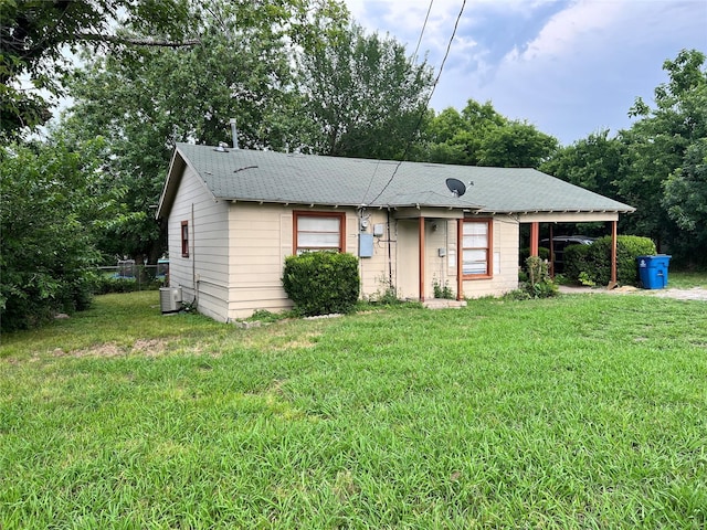 view of front of property featuring cooling unit and a front lawn