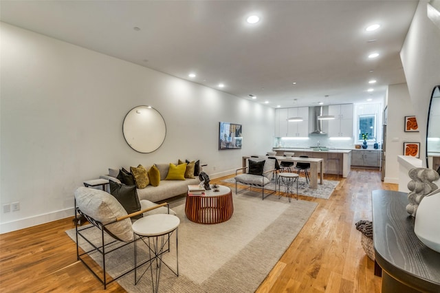 living area featuring recessed lighting, light wood-style flooring, and baseboards