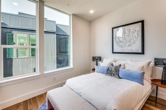 bedroom with wood-type flooring and multiple windows