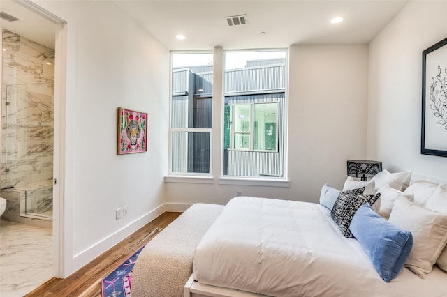 bedroom featuring hardwood / wood-style floors and connected bathroom