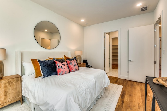 bedroom featuring hardwood / wood-style floors, a spacious closet, and a closet