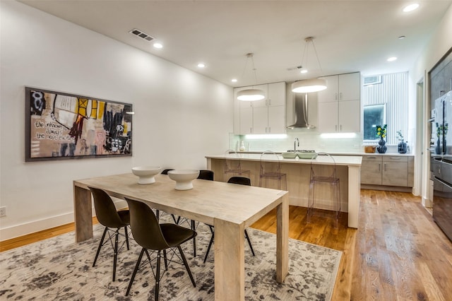 dining room featuring light wood-type flooring and sink