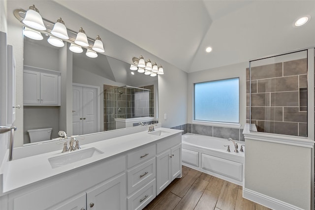 full bathroom featuring toilet, vanity, vaulted ceiling, and independent shower and bath