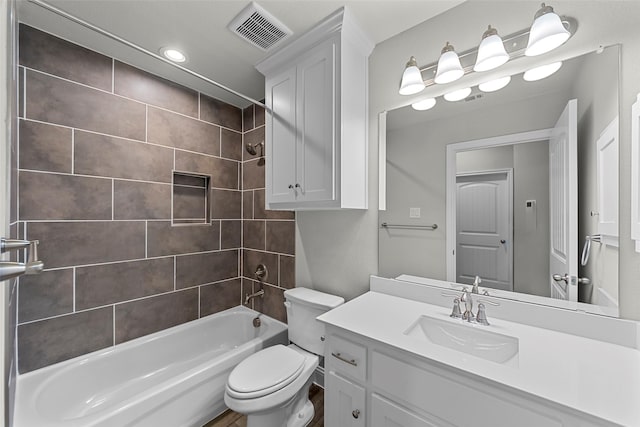 full bathroom with vanity, tiled shower / bath combo, and toilet