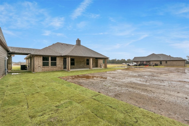 rear view of house featuring a lawn, a patio area, and central AC